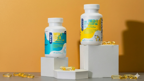 Two bottles of Omega-3 supplements on a white platform with a yellow background